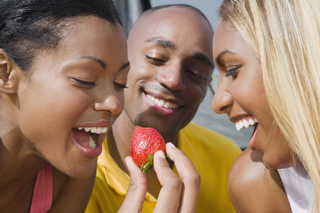 Hispanic woman eating strawberryの写真素材