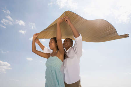 African couple holding mat in windの写真素材