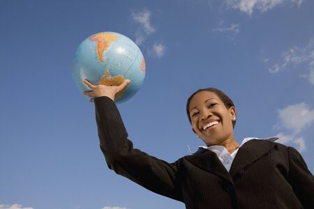 African businesswoman holding globeの写真素材