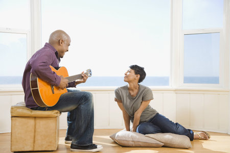 African man playing guitar for wifeの写真素材