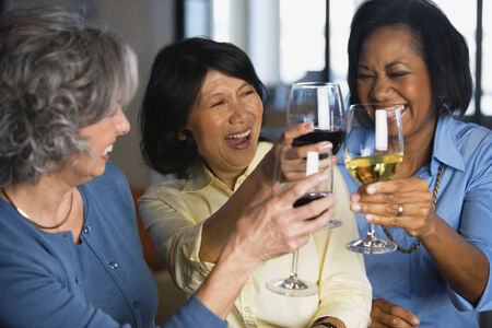 Multi-ethnic women toasting with wineの写真素材