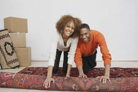 African couple rolling rugの写真素材