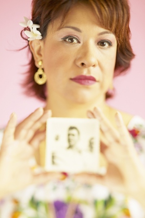 Portrait of mid adult woman holding a photographの写真素材