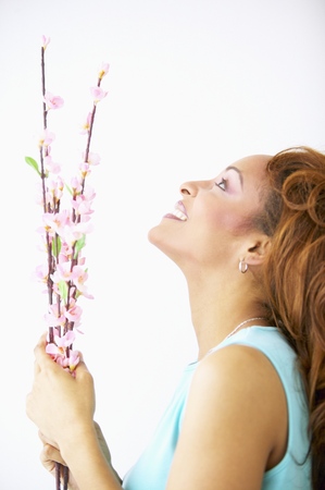 Side profile of a young woman holding a flower stalkの写真素材