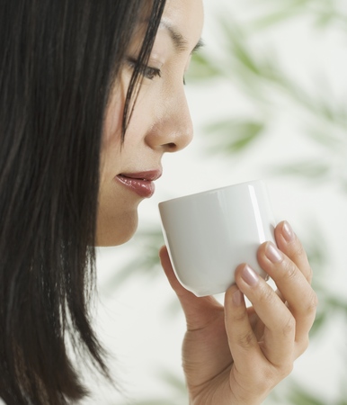 Side profile of a mid adult woman holding a cupの写真素材