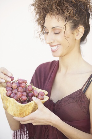 Woman holding a bowl of grapesの写真素材