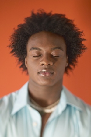 Young man standing with his eyes closed