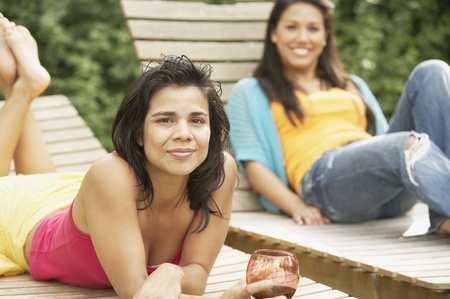 Two women lying on lounge chairsの写真素材