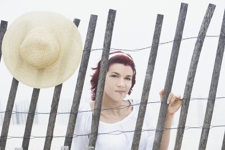 Young woman smiling for the camera behind a makeshift fenceの写真素材