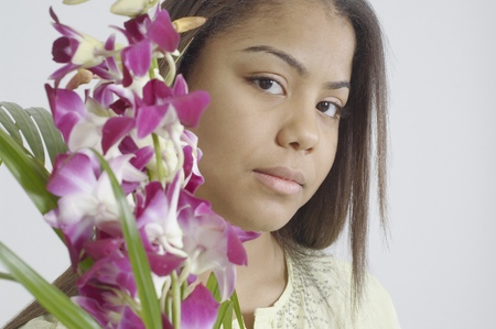 Teenage girl holding a bunch of purple flowersの写真素材