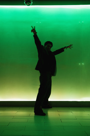 Silhouette of man dancing in nightclubの写真素材