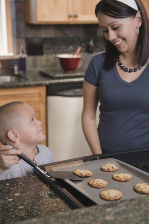 Hispanic mother and son baking cookies in kitchenの写真素材