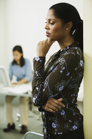 African businesswoman leaning against wallの写真素材