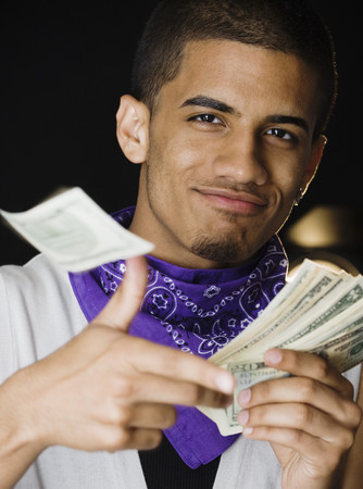 Hispanic teenage boy throwing money