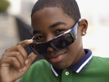 African teenage boy peering over sunglasses