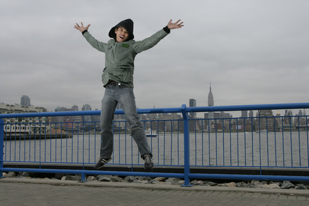 Happy Chinese man jumping on bridgeの写真素材