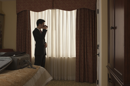 Chinese businessman drinking coffee in hotel roomの写真素材
