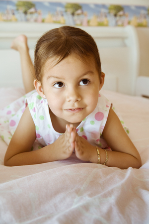 Hispanic girl praying on bedの写真素材