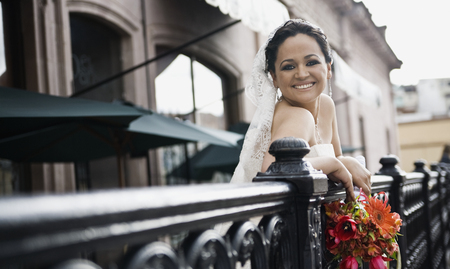 Hispanic bride on balcony smilingの写真素材