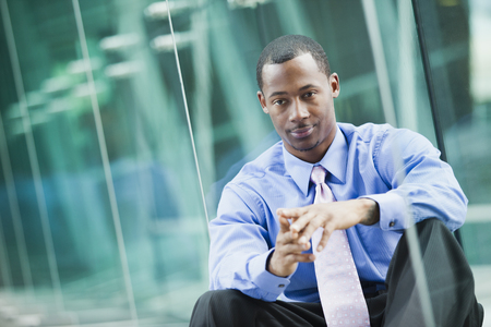 Black businessman sitting outdoorsの写真素材
