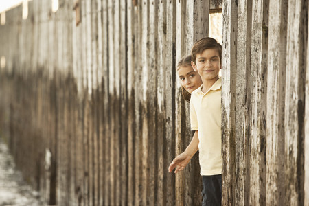 Mixed race brother and sister playing near wallの写真素材
