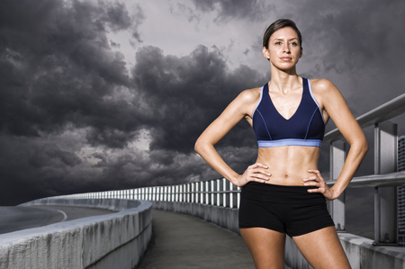 Hispanic woman in sportswear standing with hands on hipsの写真素材