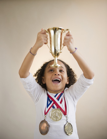 African American girl holding up trophyの写真素材