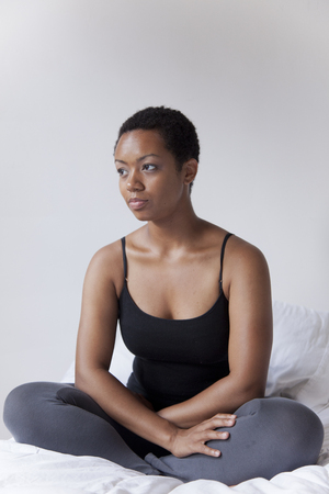 African American sitting in bedの写真素材