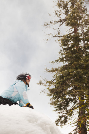 Smiling girl kneeling in snowの写真素材