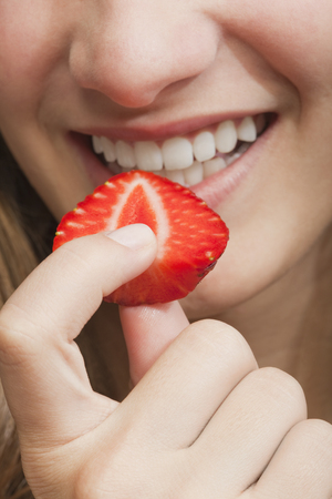 Hispanic girl eating strawberryの写真素材