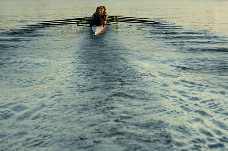 Team rowing boat in bay