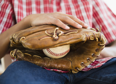 African American boy holding baseball and gloveの写真素材