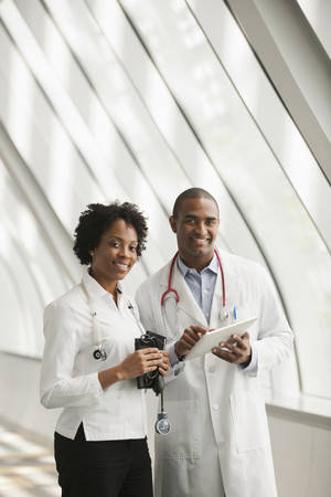 Doctors using digital tablet in hospital corridorの写真素材