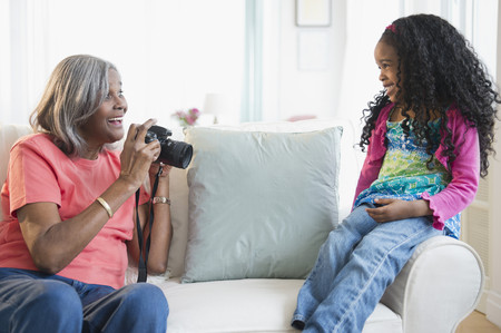 African American woman taking pictures of granddaughterの写真素材