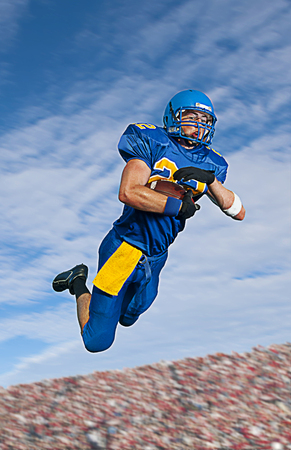 Caucasian football player catching ball
