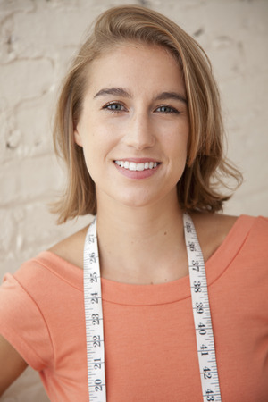 Caucasian woman with measuring tape around her neckの写真素材