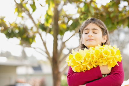 Mixed race girl holding flowersの写真素材