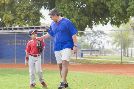 Hispanic coach and young baseball playerの写真素材