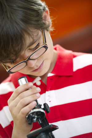 Hispanic boy using microscopeの写真素材