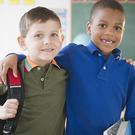 Boys hugging in classroomの写真素材