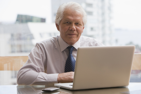 Chilean businessman sitting at desk with laptopの写真素材