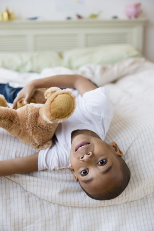 African American boy laying on bedの写真素材