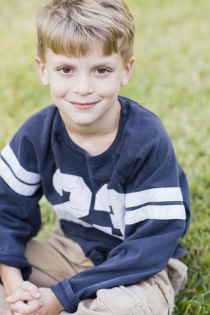 Caucasian boy smiling on lawnの写真素材