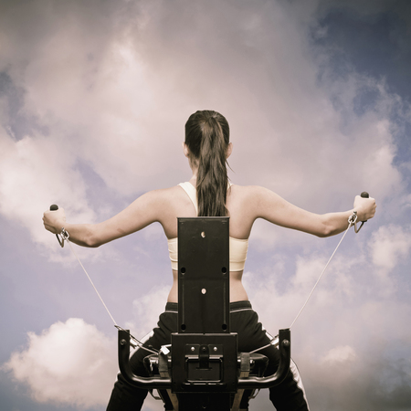 Woman using exercise machine outdoorsの写真素材