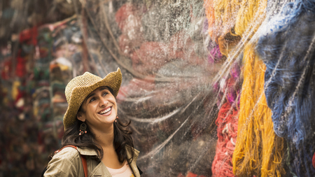 Hispanic woman admiring yarn for sale