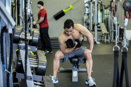 Pacific Islander man lifting weights in gymの写真素材