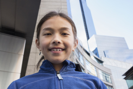 Mixed race girl smiling on city streetの写真素材