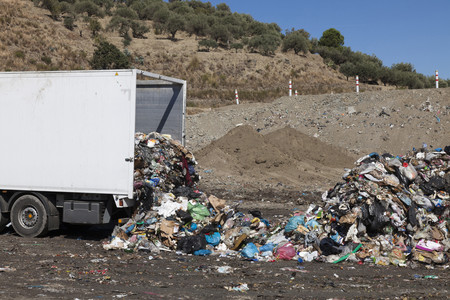 Truck dumping refuse into landfill
