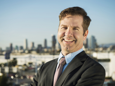 Caucasian businessman standing on urban rooftop