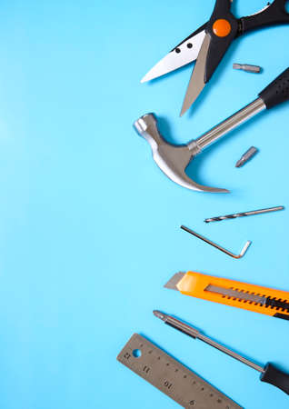A selection of home improvement tools laid out on a blue background to form a page border